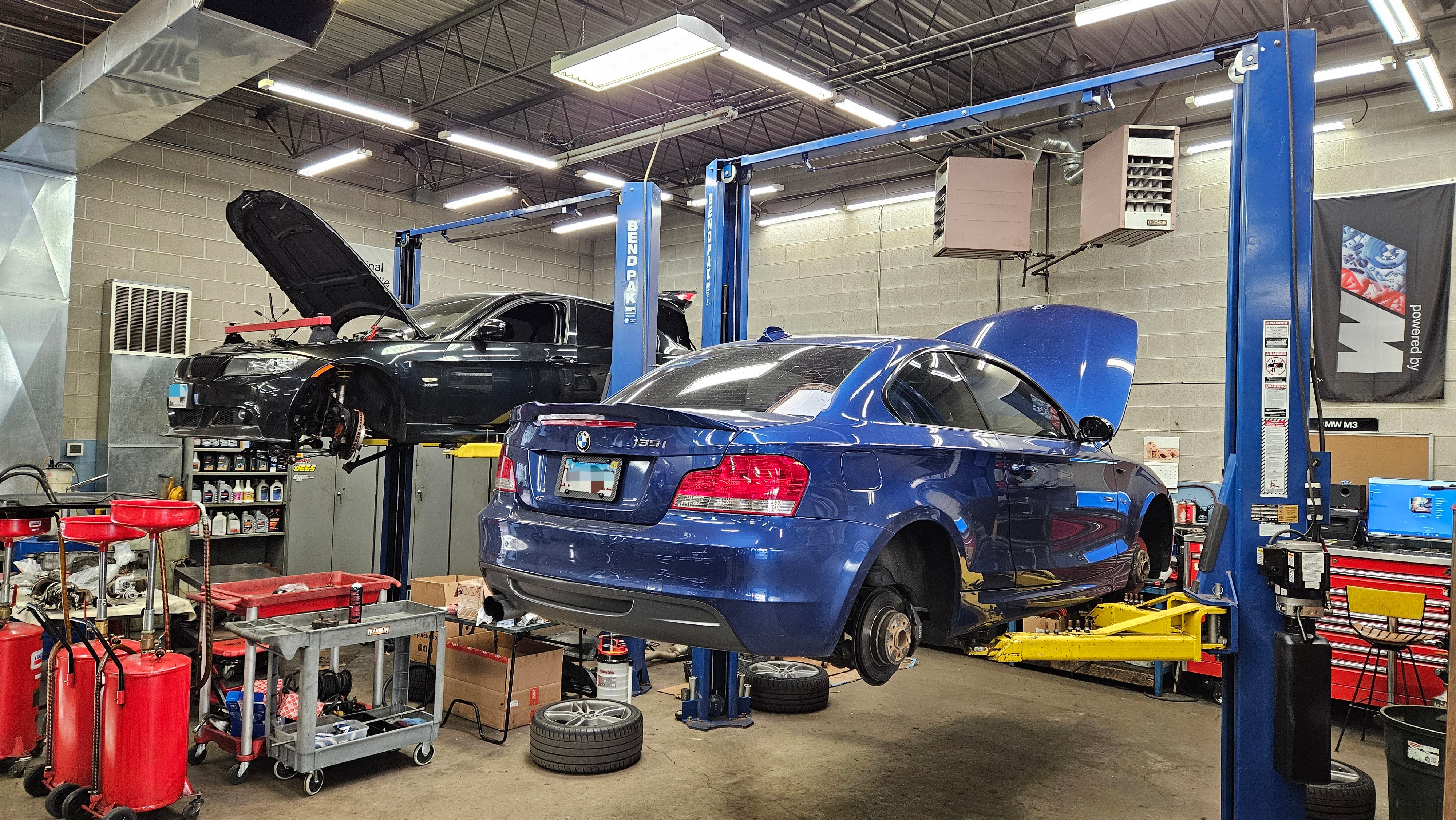 Adam's AutoHaus German Specialty Workshop Roselle interior with BMW on hydraulic lift for precision service
